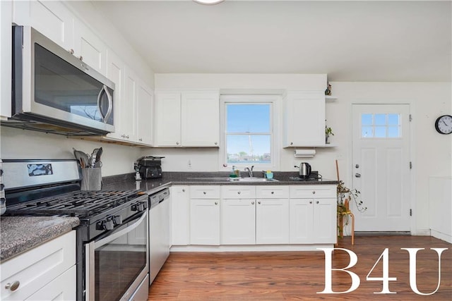 kitchen with white cabinets, dark hardwood / wood-style floors, and appliances with stainless steel finishes