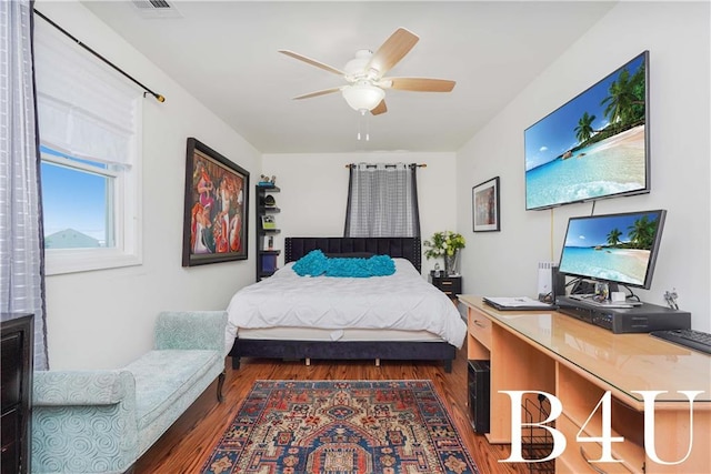 bedroom with dark hardwood / wood-style flooring and ceiling fan