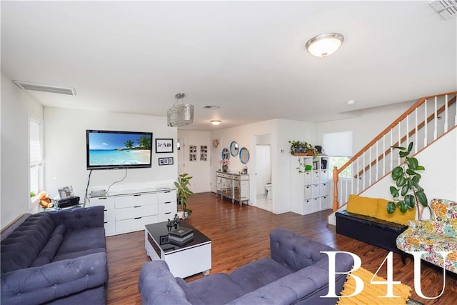 living area featuring visible vents, wood finished floors, and stairs