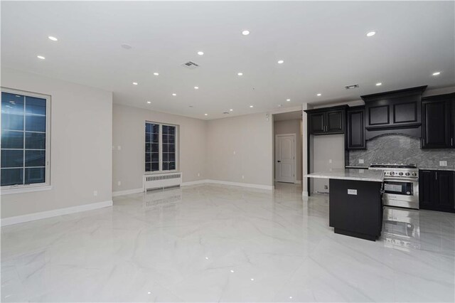 kitchen featuring high end range, backsplash, a center island, and a kitchen bar