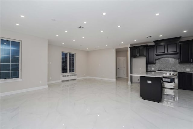 kitchen with high end stainless steel range oven, a breakfast bar, dark cabinets, and a center island