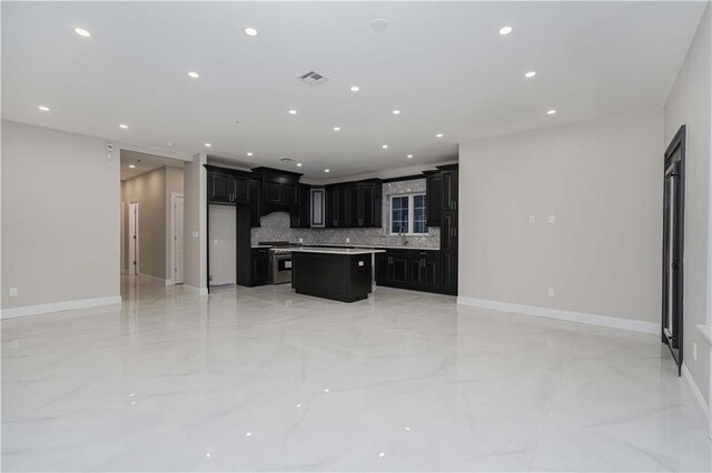 kitchen featuring decorative backsplash, stainless steel stove, and a kitchen island