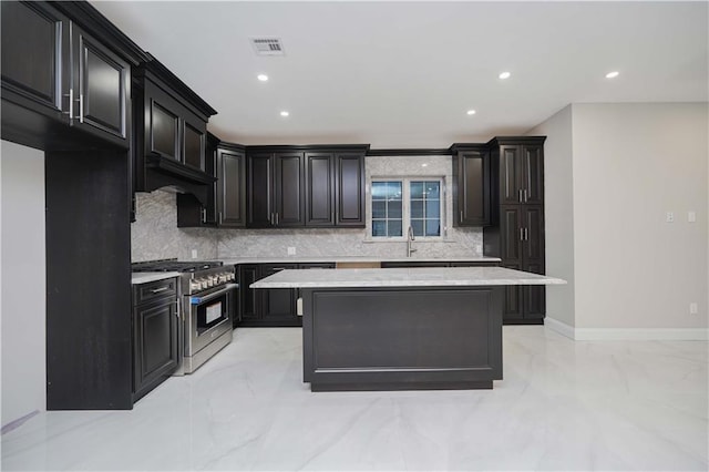 kitchen with visible vents, stainless steel range, a center island, marble finish floor, and light countertops