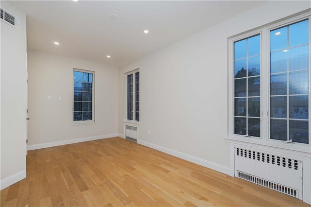 empty room with radiator and light hardwood / wood-style floors