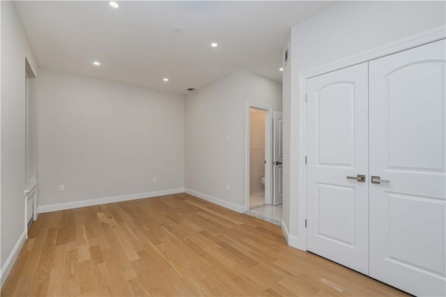 unfurnished bedroom with light wood-style floors, baseboards, connected bathroom, and recessed lighting