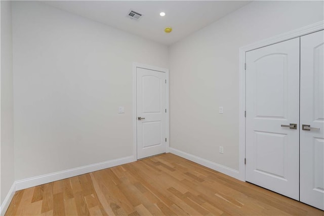 unfurnished bedroom with recessed lighting, visible vents, baseboards, and wood finished floors