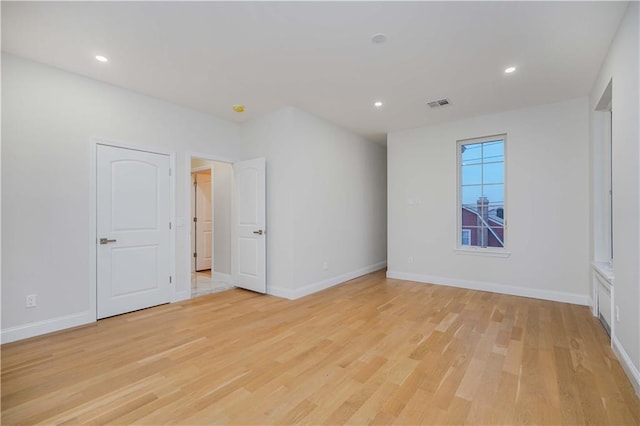 empty room featuring light wood-type flooring and baseboards