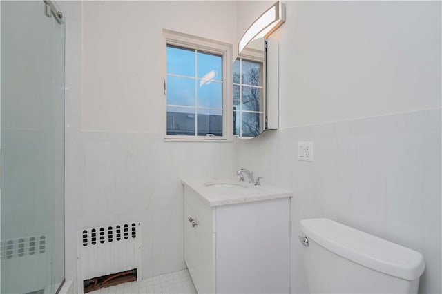 bathroom with toilet, a wainscoted wall, radiator heating unit, and vanity