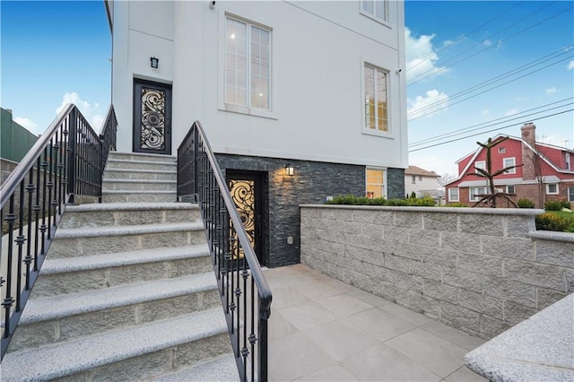 exterior space with stone siding and stucco siding