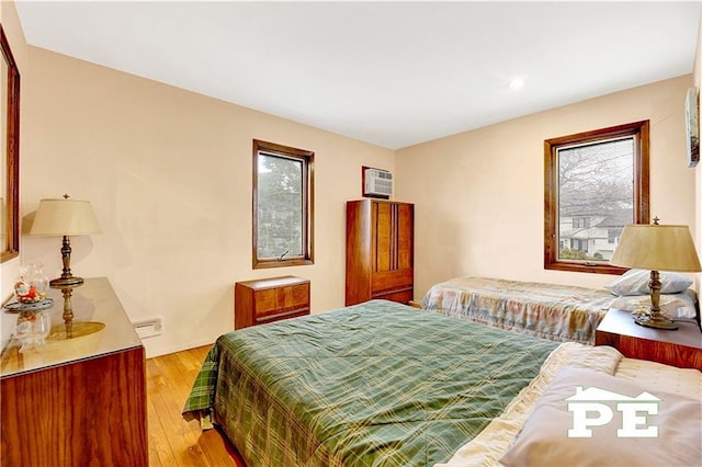 bedroom featuring light wood-type flooring and a wall mounted AC