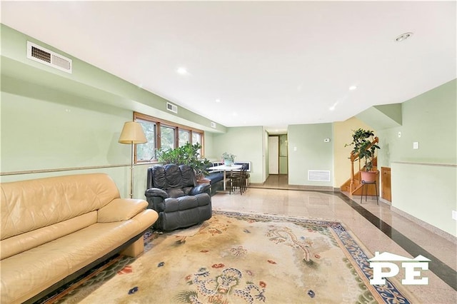 living room featuring baseboards, visible vents, and recessed lighting