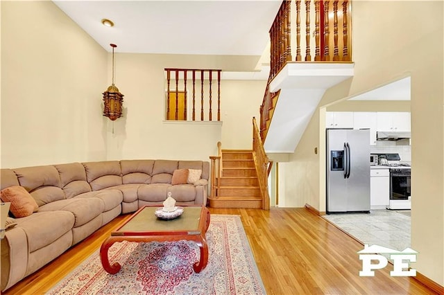 living room featuring stairs and light wood-type flooring