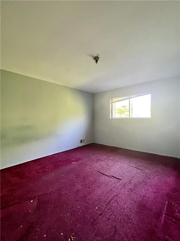 carpeted empty room featuring visible vents