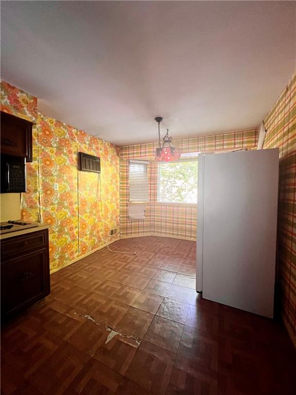 unfurnished dining area with dark parquet floors