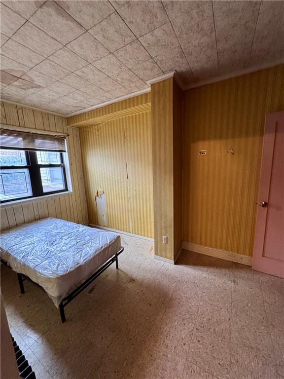 unfurnished bedroom featuring wood walls and light floors