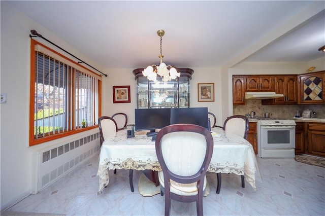 dining area featuring radiator heating unit and a chandelier