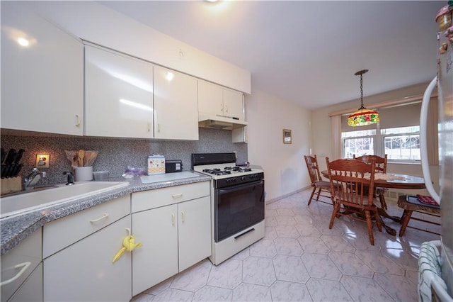 kitchen featuring backsplash, white appliances, sink, pendant lighting, and white cabinets