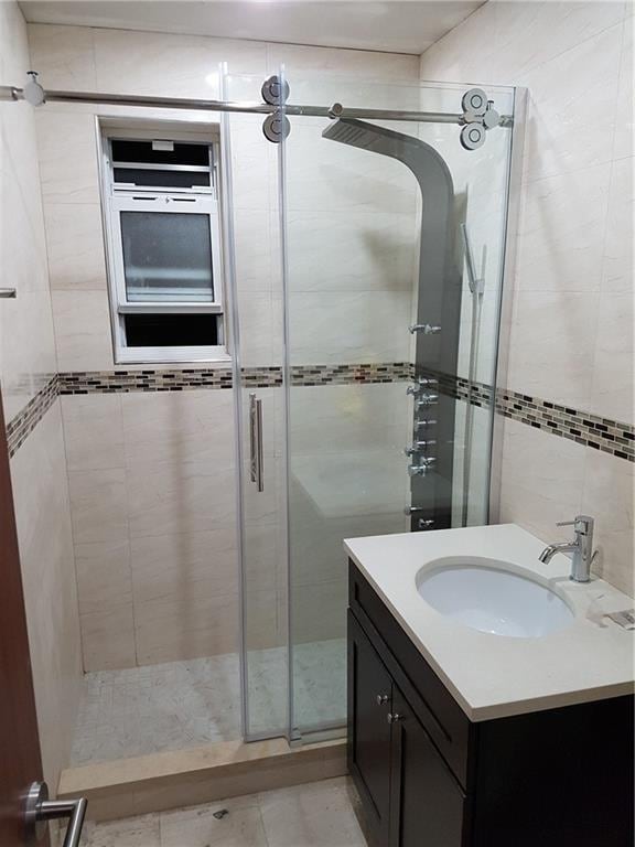 bathroom featuring tile patterned floors, vanity, and a shower with shower door