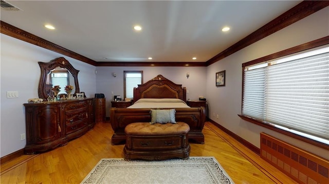 bedroom featuring light hardwood / wood-style floors, radiator heating unit, and crown molding