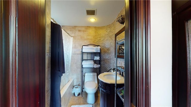 full bathroom with tile patterned flooring, toilet, shower / tub combo with curtain, vanity, and tile walls