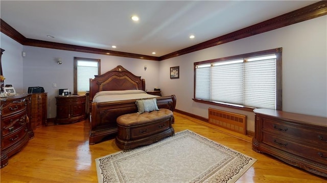 bedroom with ornamental molding, radiator, and light hardwood / wood-style flooring