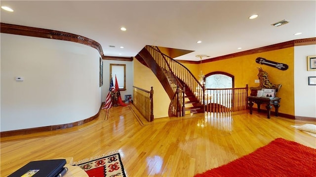 interior space featuring hardwood / wood-style flooring, a notable chandelier, and crown molding