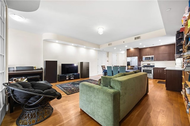 living area with recessed lighting, visible vents, and light wood finished floors