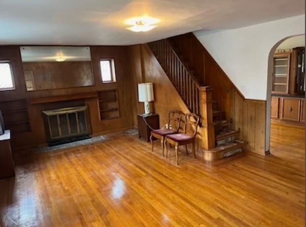 unfurnished room with wood walls and light wood-type flooring