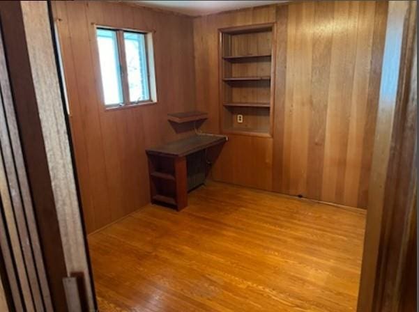 interior space featuring light hardwood / wood-style floors and wooden walls