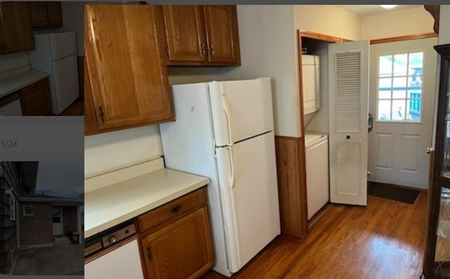 kitchen with stacked washing maching and dryer, white appliances, and light hardwood / wood-style floors