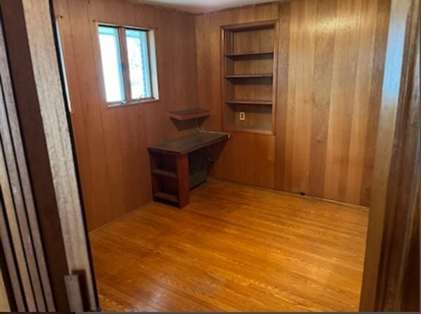 interior space featuring light hardwood / wood-style flooring and wood walls