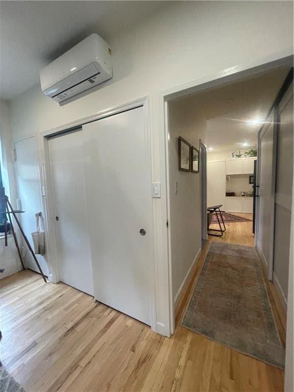 hallway featuring a wall mounted AC and light hardwood / wood-style floors