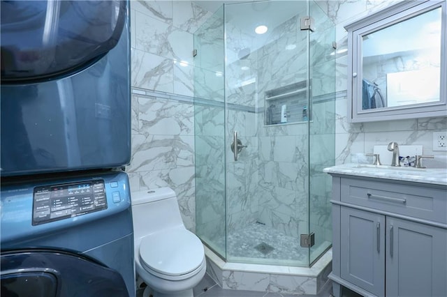 bathroom featuring an enclosed shower, vanity, toilet, and tile walls