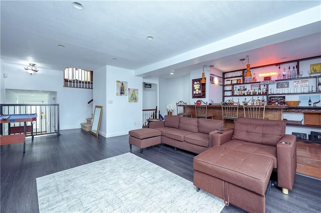 living room with bar area and dark wood-type flooring