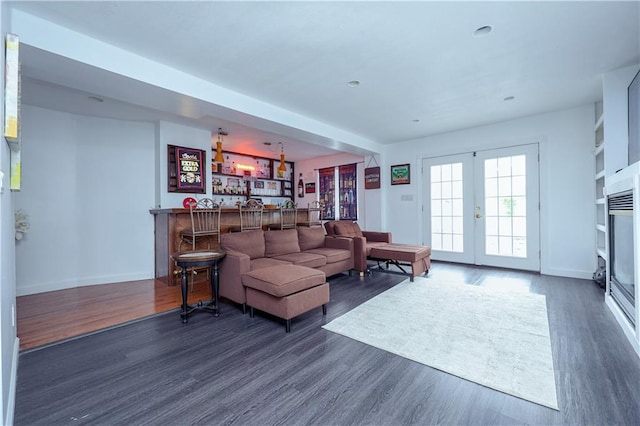 living room with bar, dark hardwood / wood-style flooring, and french doors