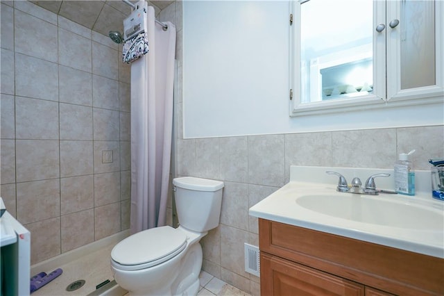 bathroom with walk in shower, vanity, toilet, and tile walls