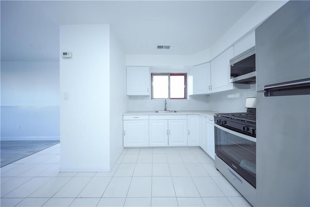 kitchen with backsplash, sink, white cabinets, and appliances with stainless steel finishes