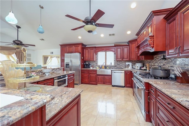 kitchen with decorative light fixtures, decorative backsplash, light stone countertops, and appliances with stainless steel finishes