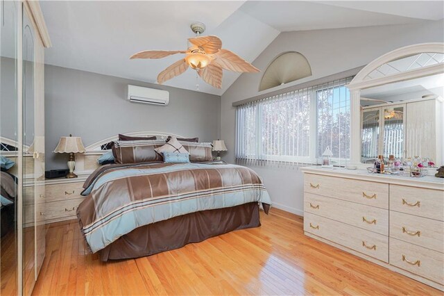 bedroom featuring a wall mounted air conditioner, ceiling fan, light hardwood / wood-style floors, and lofted ceiling