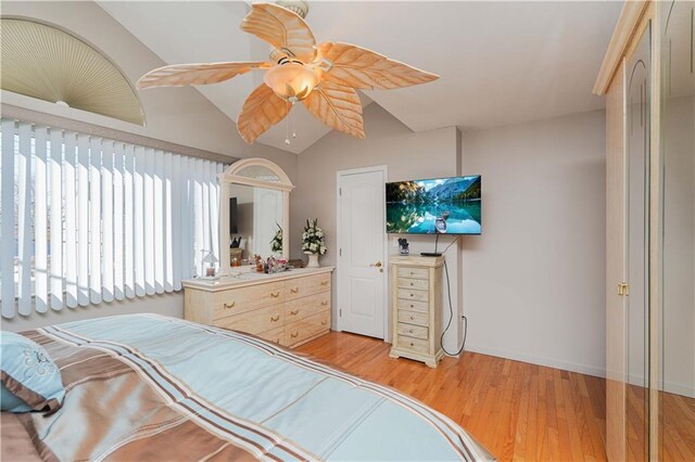 bedroom with light hardwood / wood-style flooring, ceiling fan, and lofted ceiling