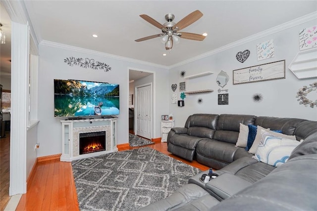 living room with a fireplace, wood-type flooring, and ornamental molding