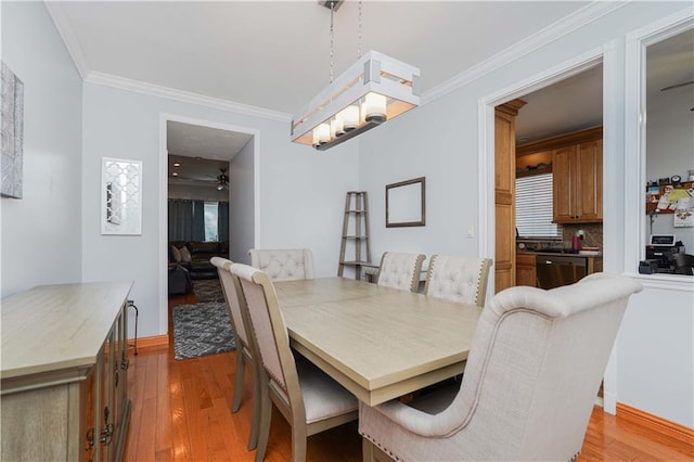 dining area featuring crown molding and light hardwood / wood-style flooring