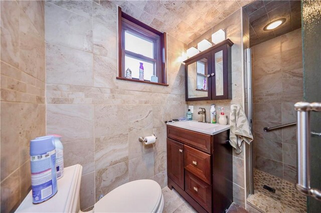 bathroom featuring vanity, a shower with door, and tile walls