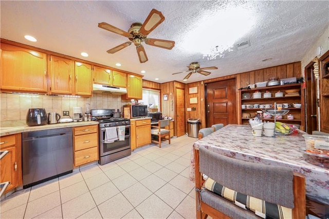 kitchen with light tile patterned floors, a textured ceiling, stainless steel appliances, and ceiling fan