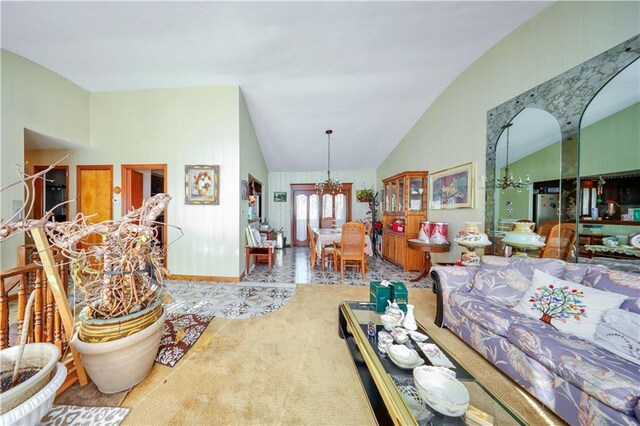 living room featuring carpet flooring, a chandelier, and vaulted ceiling