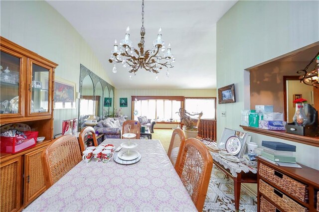 dining room with a notable chandelier and vaulted ceiling