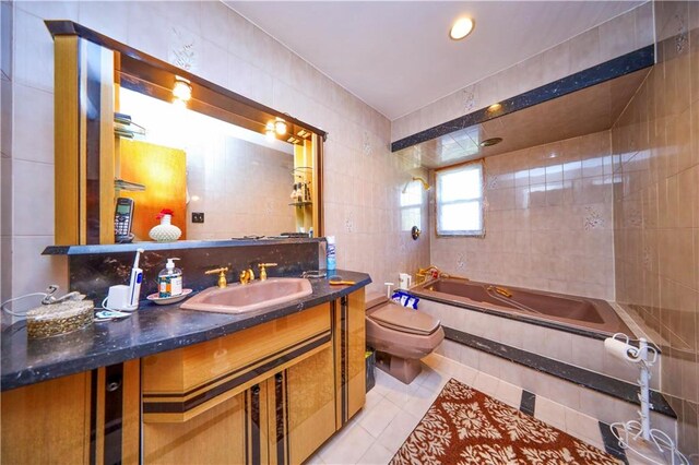 bathroom with vanity, tile patterned flooring, a washtub, toilet, and tile walls