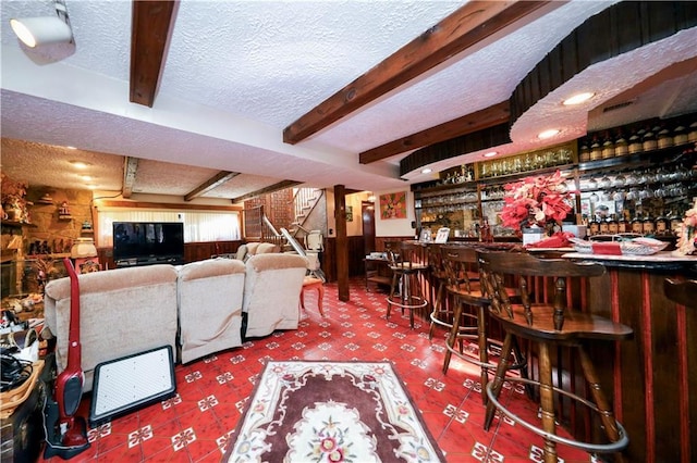 bar featuring beam ceiling, carpet, and a textured ceiling