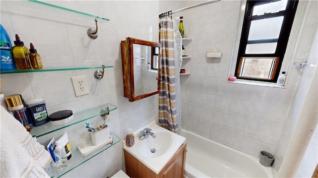 bathroom with tile walls, plenty of natural light, vanity, and shower / bath combo