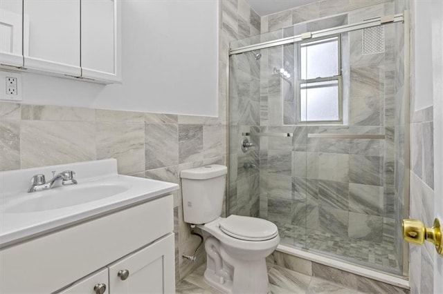 bathroom featuring vanity, tile walls, toilet, and walk in shower